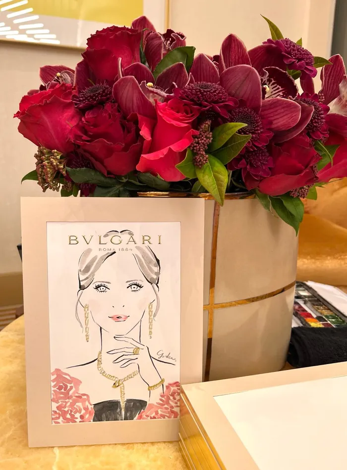 Bouquet of red flowers with Bulgari event card and books