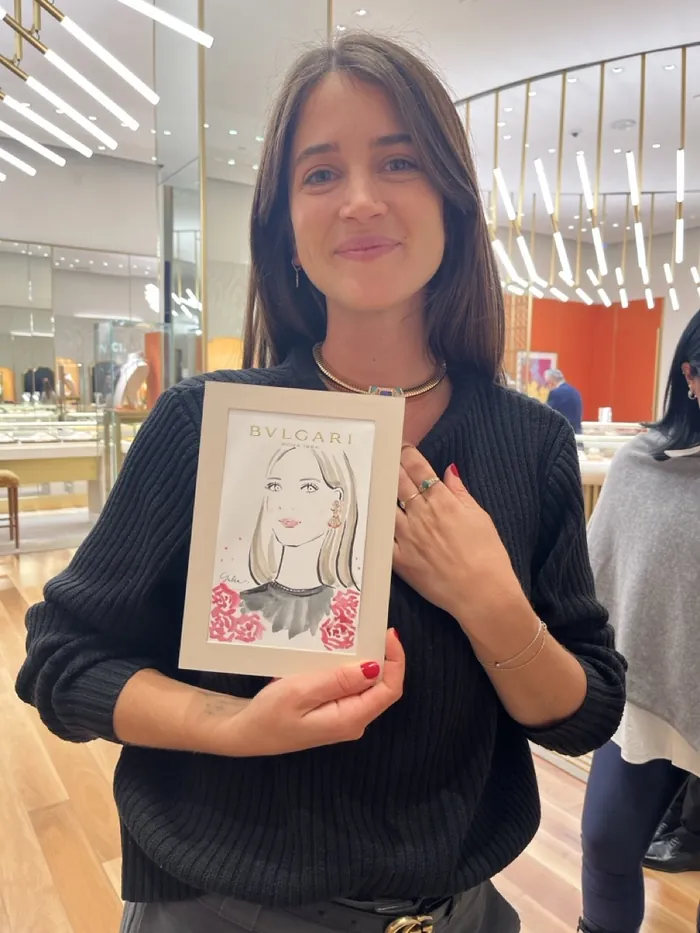 Woman holding Bulgari illustration at luxury event