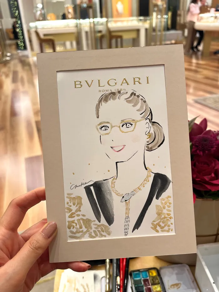 Hand holding a Bulgari event sketch of a woman wearing jewelry
