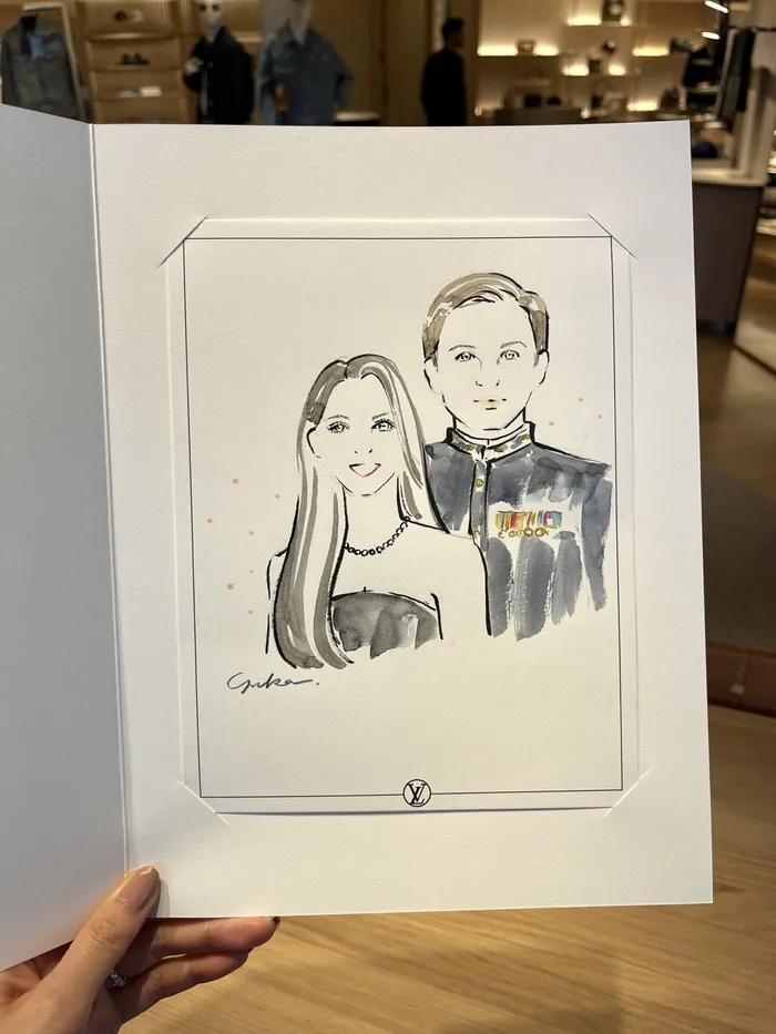 Hand holding a black and white caricature of a man and woman