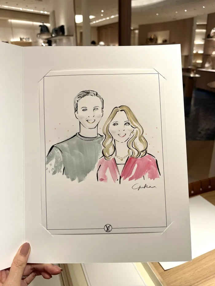 Hand holding a sketch of a smiling man and woman