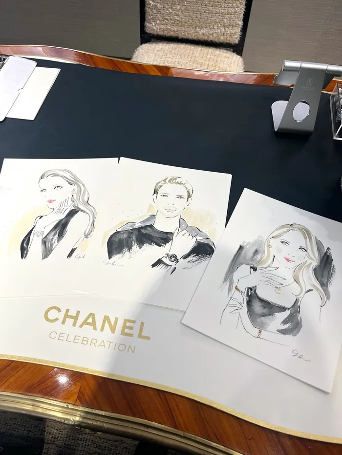 Sketches of women in Chanel celebration event displayed on a table