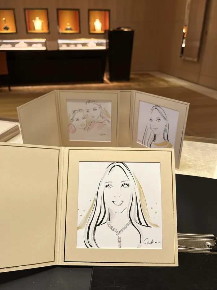 Hand-drawn portraits displayed on a table at a Bulgari event