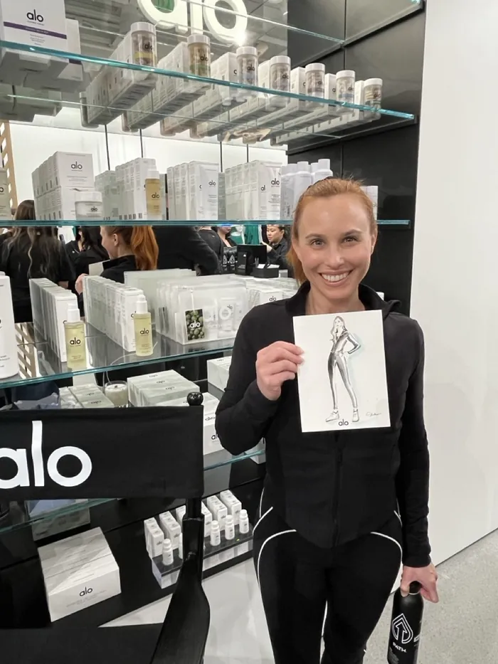 Woman holding fashion sketch at Alo live event in store