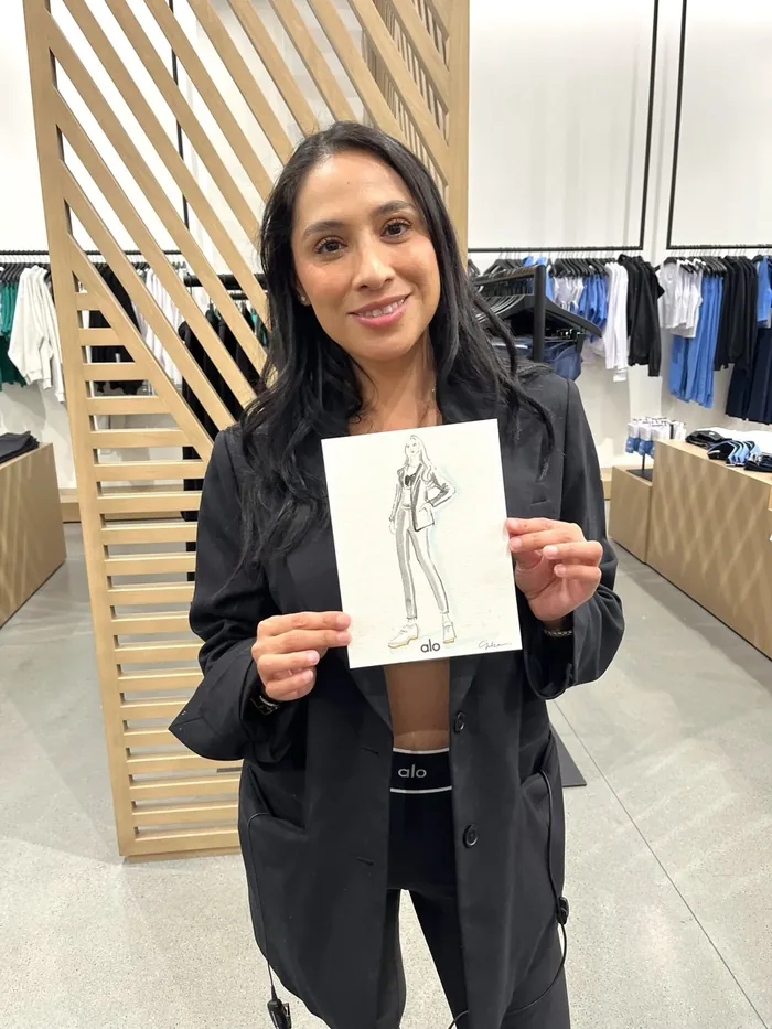 Woman holding a fashion sketch inside a clothing store