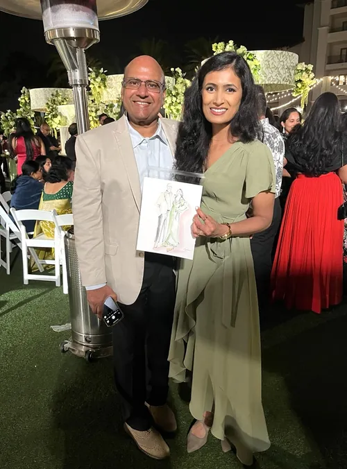 Smiling man and woman holding artwork at outdoor event