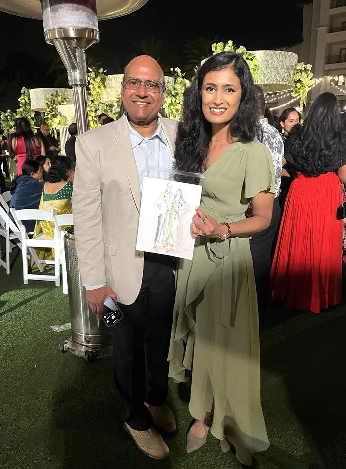 Smiling man and woman holding artwork at outdoor event