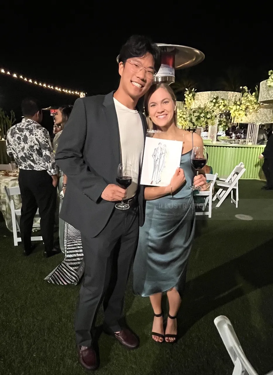 Smiling couple holding wine glasses at outdoor evening event