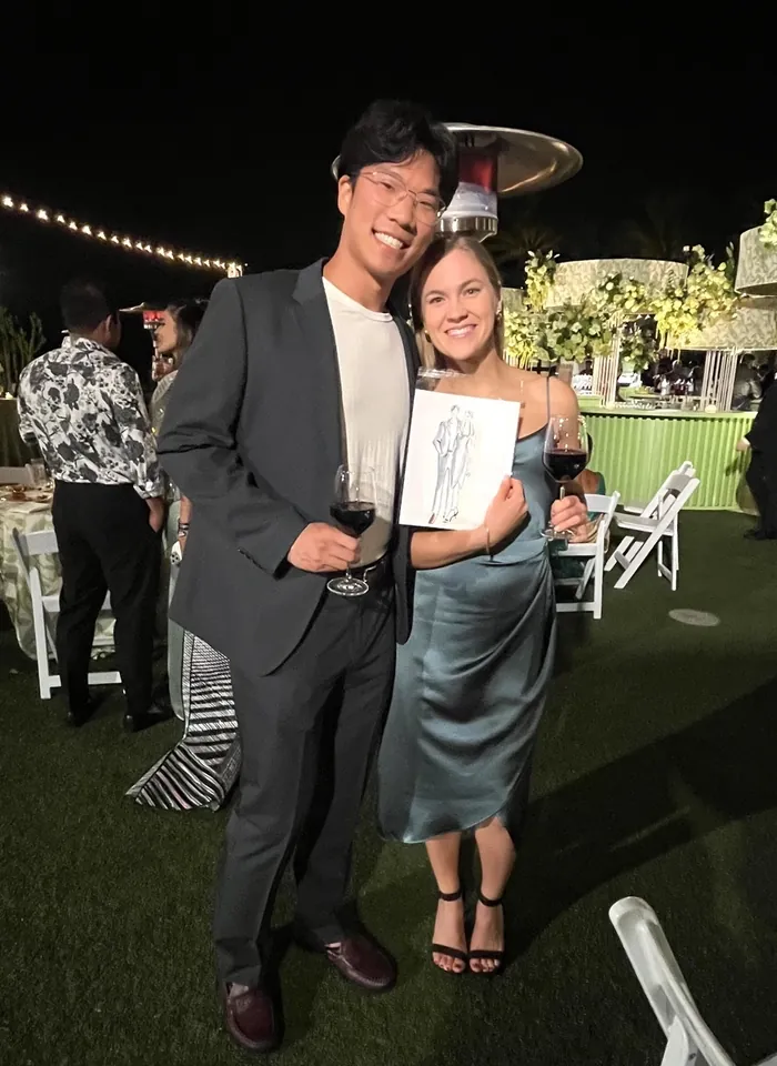 Smiling couple holding wine glasses at outdoor evening event