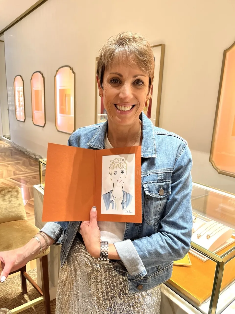 Woman smiling holding a caricature portrait at Bulgari event