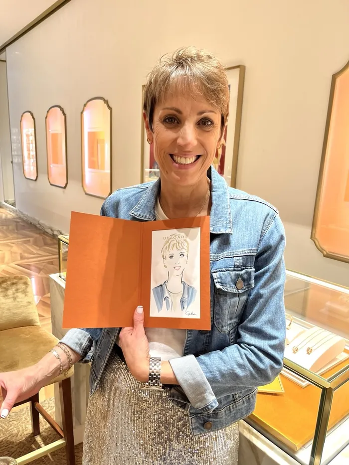 Woman smiling holding a caricature portrait at Bulgari event