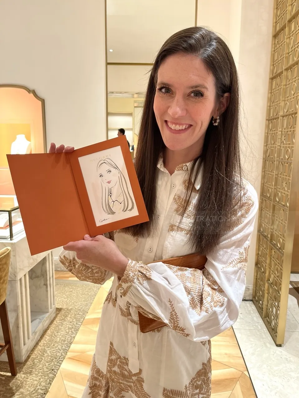 Woman smiling holding framed sketch in elegant interior