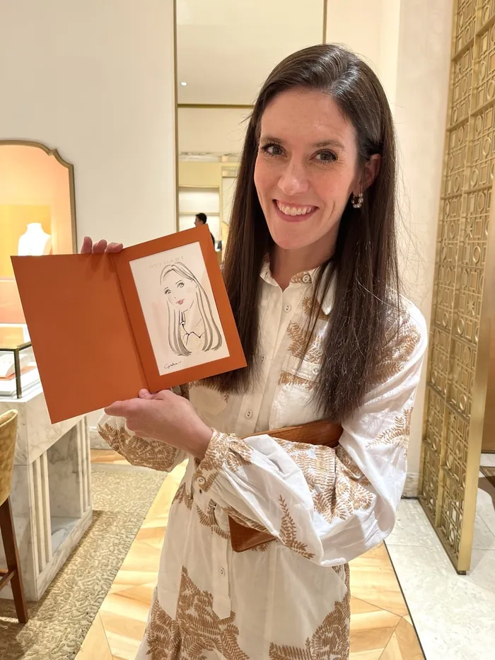 Woman smiling holding framed sketch in elegant interior