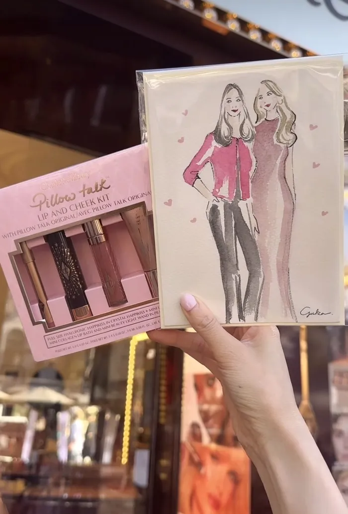 Hand holding Charlotte Tilbury makeup set and fashion illustration