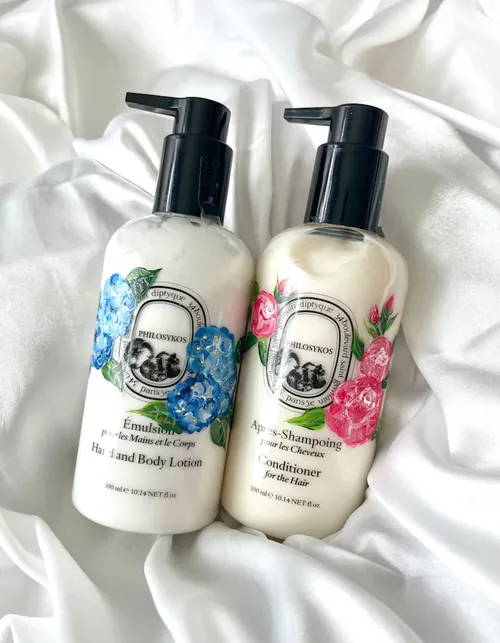 Two Diptyque lotion and shampoo bottles with floral designs