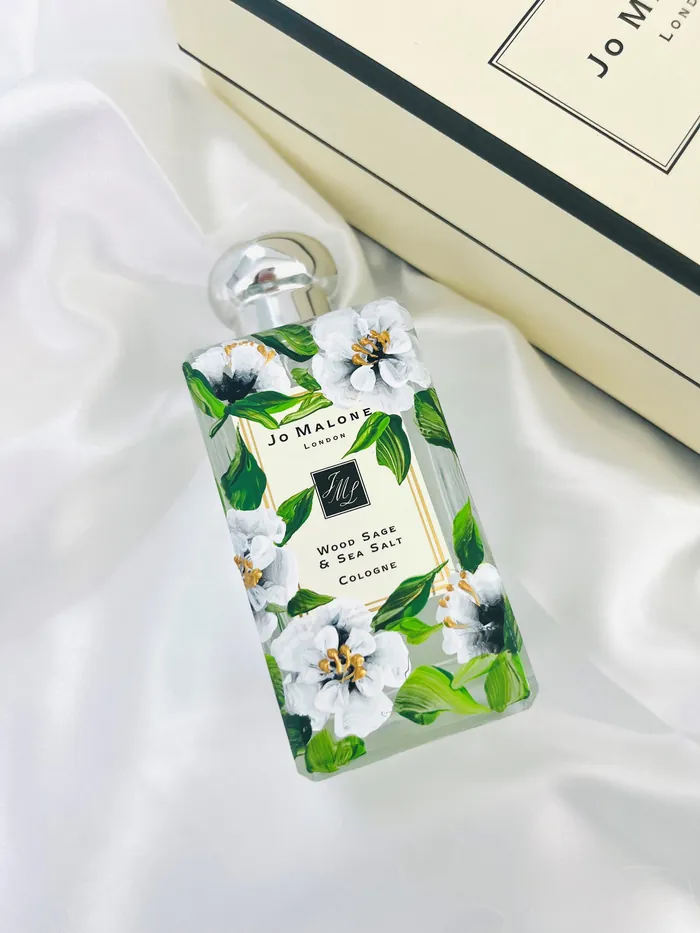 Jo Malone perfume bottle with floral design on white satin fabric