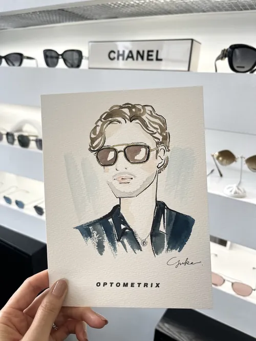 Hand holding illustrated portrait of man with sunglasses in eyewear store