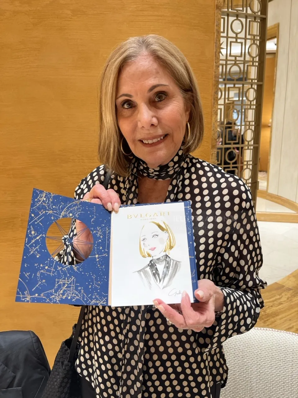 Woman showing an illustrated book by Yuka Yasutomi at Bulgari event