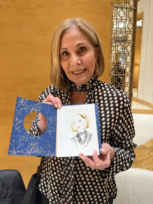 Woman showing an illustrated book by Yuka Yasutomi at Bulgari event