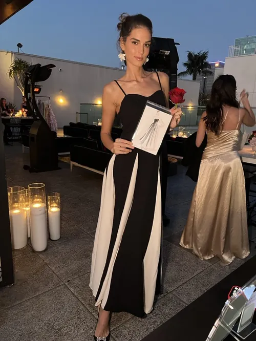 Woman in black and white dress holding award at an event by Yuka Yasutomi