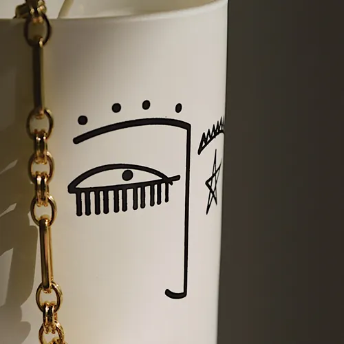 Minimalist line drawing of a face on a white mug by Nadia Flower