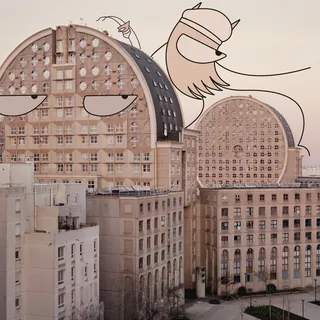 Residential buildings with cartoon faces and wings drawn on walls