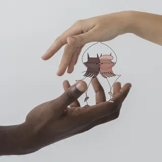 Hands holding a glass bird figurine depicting two birds facing each other