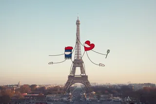 Cartoon couple holding hands and hearts around Eiffel Tower