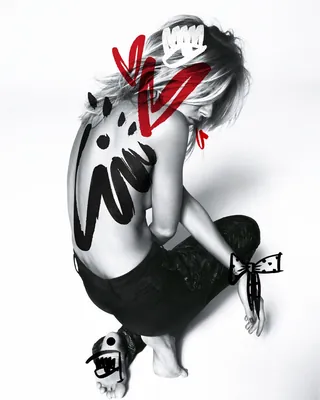 Person with abstract red and black body paint art on back and arms