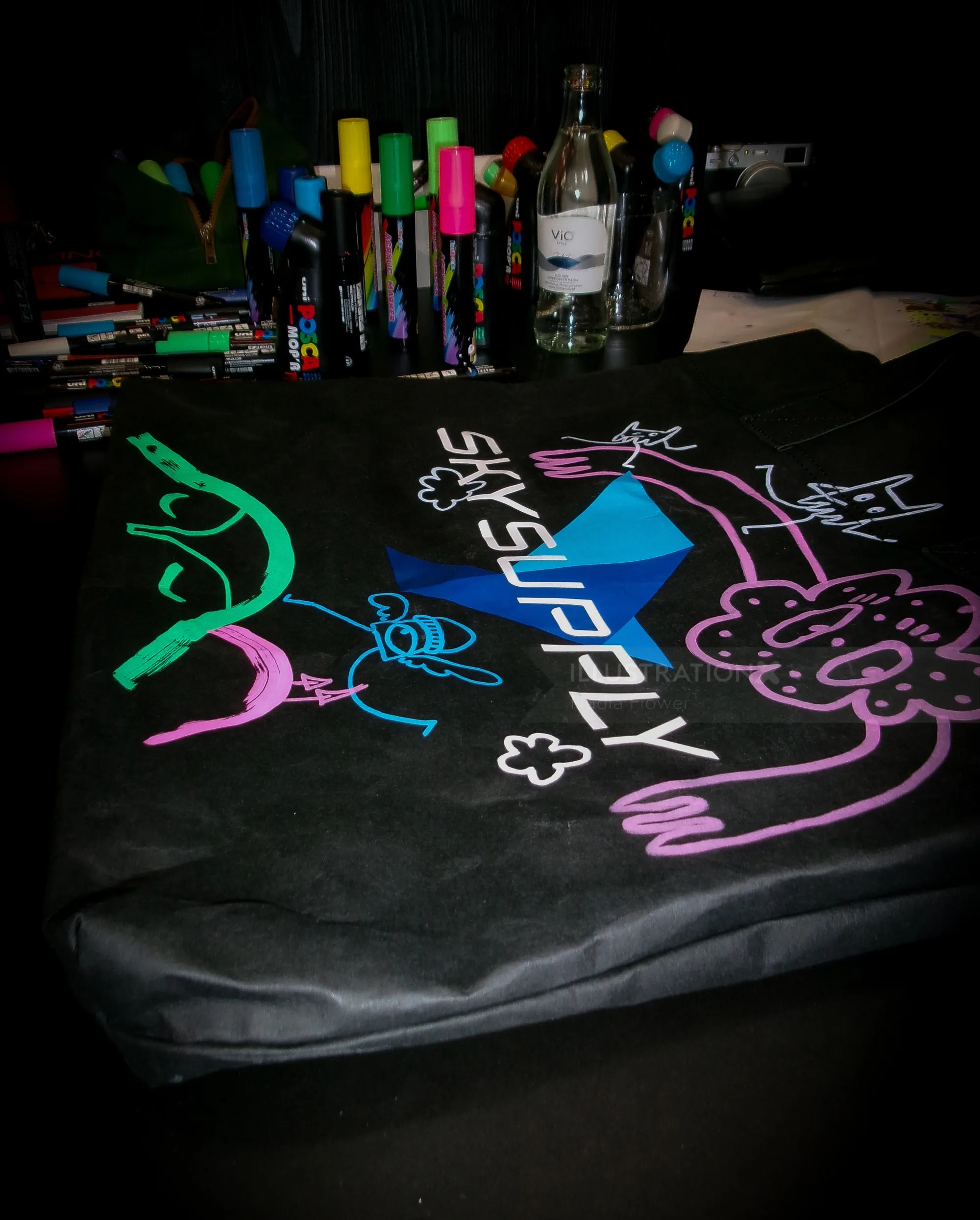 Black fabric decorated with colorful neon graffiti drawings and markers