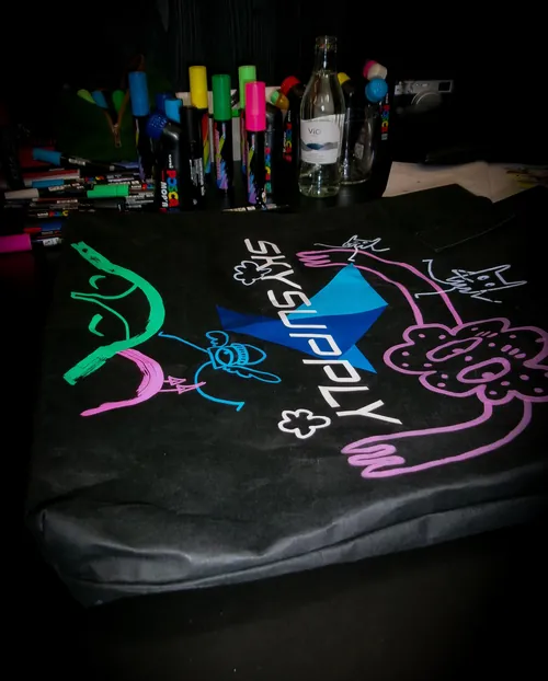 Black fabric decorated with colorful neon graffiti drawings and markers