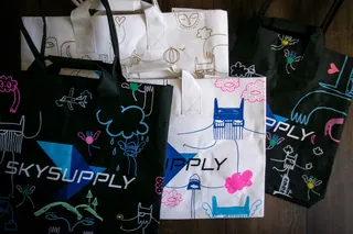 Reusable bags with colorful animal and nature illustrations on black and white backgrounds