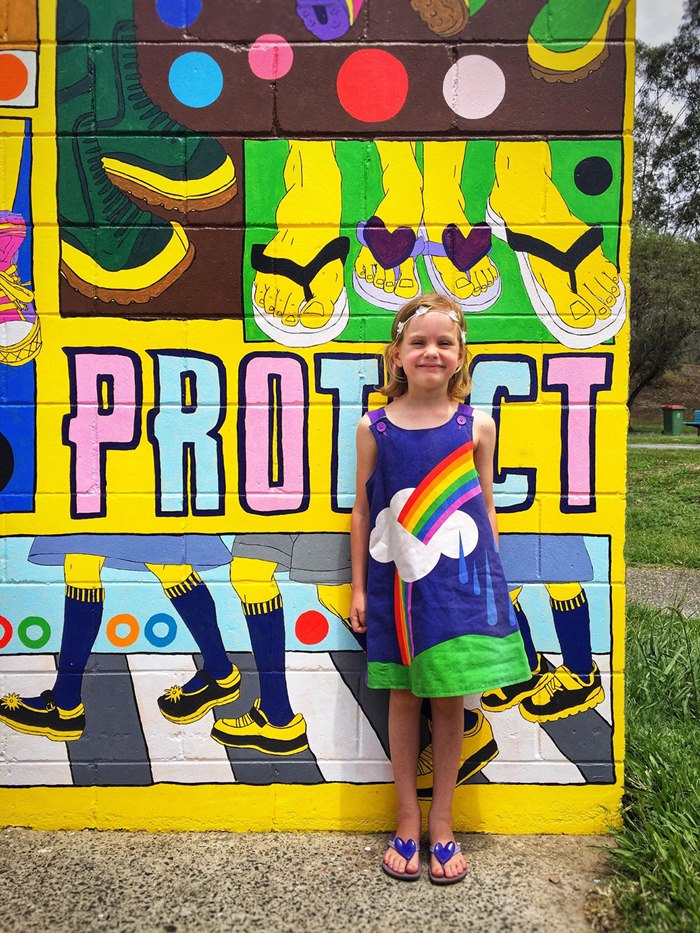 Illustration of child posing with Sarah Beetson mural art