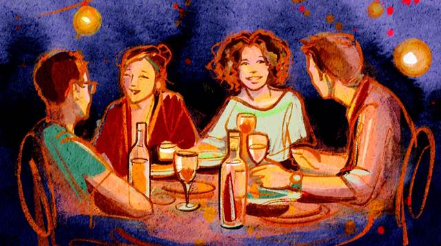 Four people enjoying a summer dinner party under string lights
